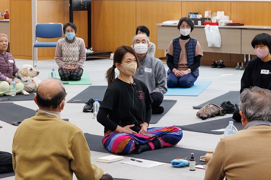 凛とした高平先生を取り囲む形でヨガに取り組む参加者のみなさん